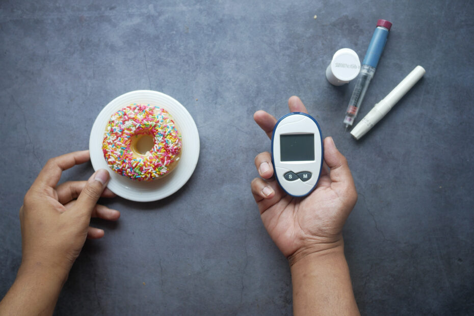Imagem mostrando um prato com um donuts e um aparelho para medir insulina